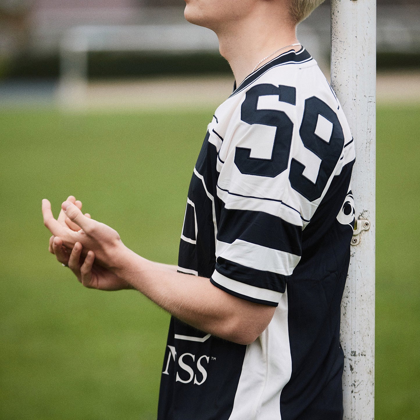 Side view of a person in a black and white Guinness football jersey with bold 59 on the back, outdoors.