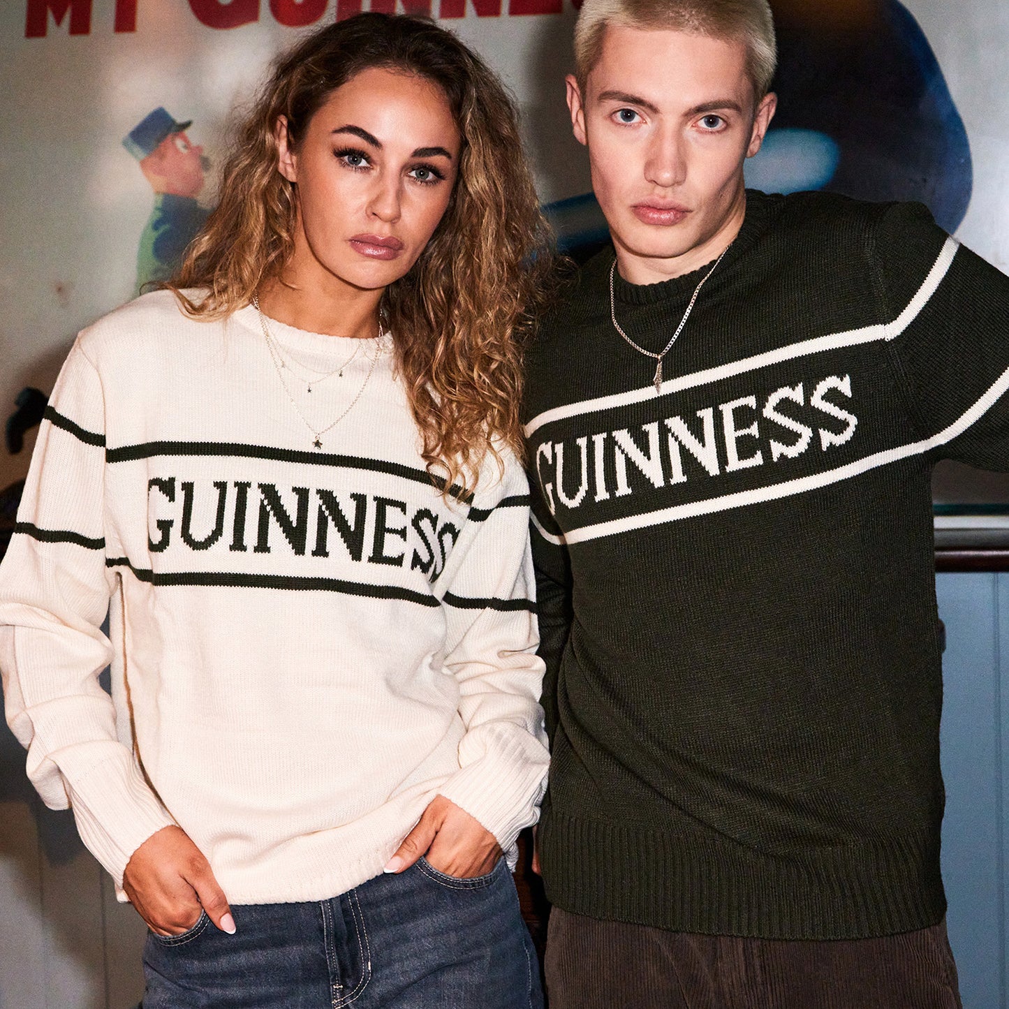 Two models wear Guinness knit sweaters cream and dark green with bold GUINNESS lettering across the chest.