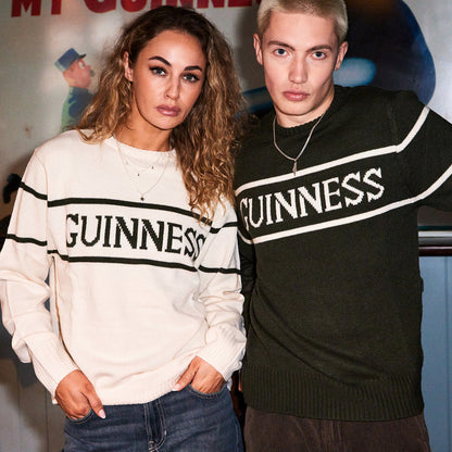 Two models wear Guinness knit sweaters cream and dark green with bold GUINNESS lettering across the chest.