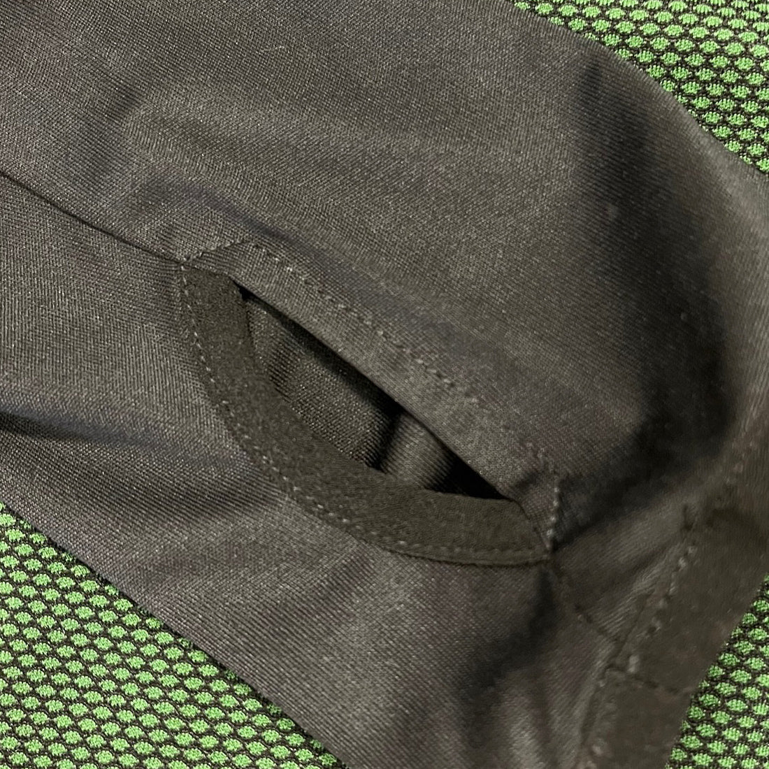 Close up of black fabric showing a stitched pocket opening from the Guinness 1759 performance top