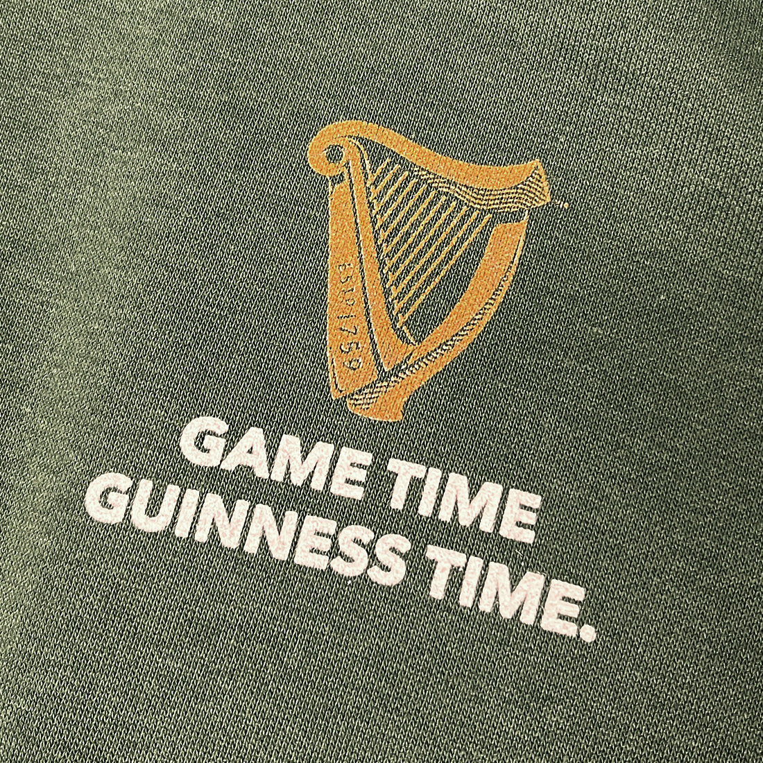 Gold harp logo with GAME TIME GUINNESS TIME text on green fabric