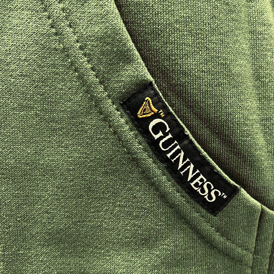 Guinness brand tag on the green hoodie pocket