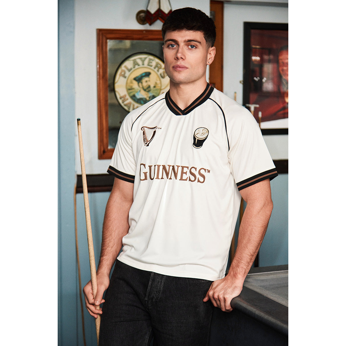 Model wearing cream Guinness Retro Pint Jersey with large Guinness text across the chest.