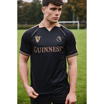 Male model wearing the Guinness black and bronze Premier League football top outdoors