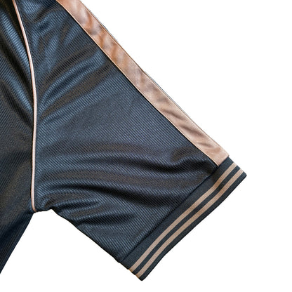 Close up of the dark navy sleeve with tan stripe trim and ribbed cuff from the Guinness football top.