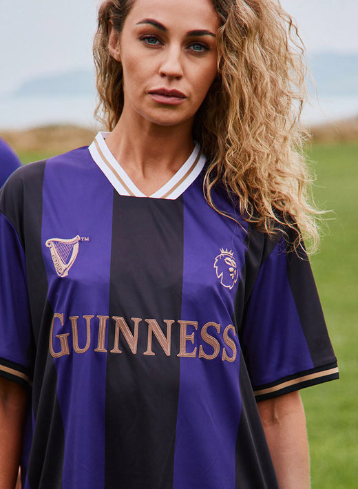 Purple and black striped Guinness Premier League football top with crest and large GUINNESS lettering