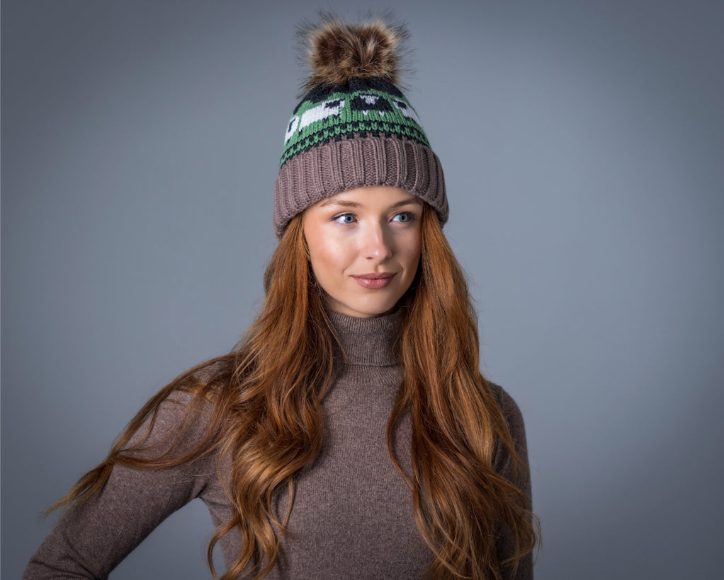 Young woman with long red hair wearing a knitted hat with pom-pom