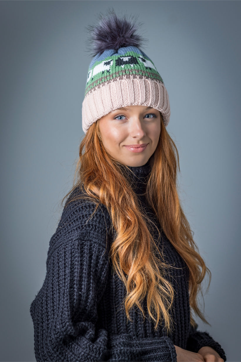 Young woman with long red hair wearing a knitted hat and black sweater