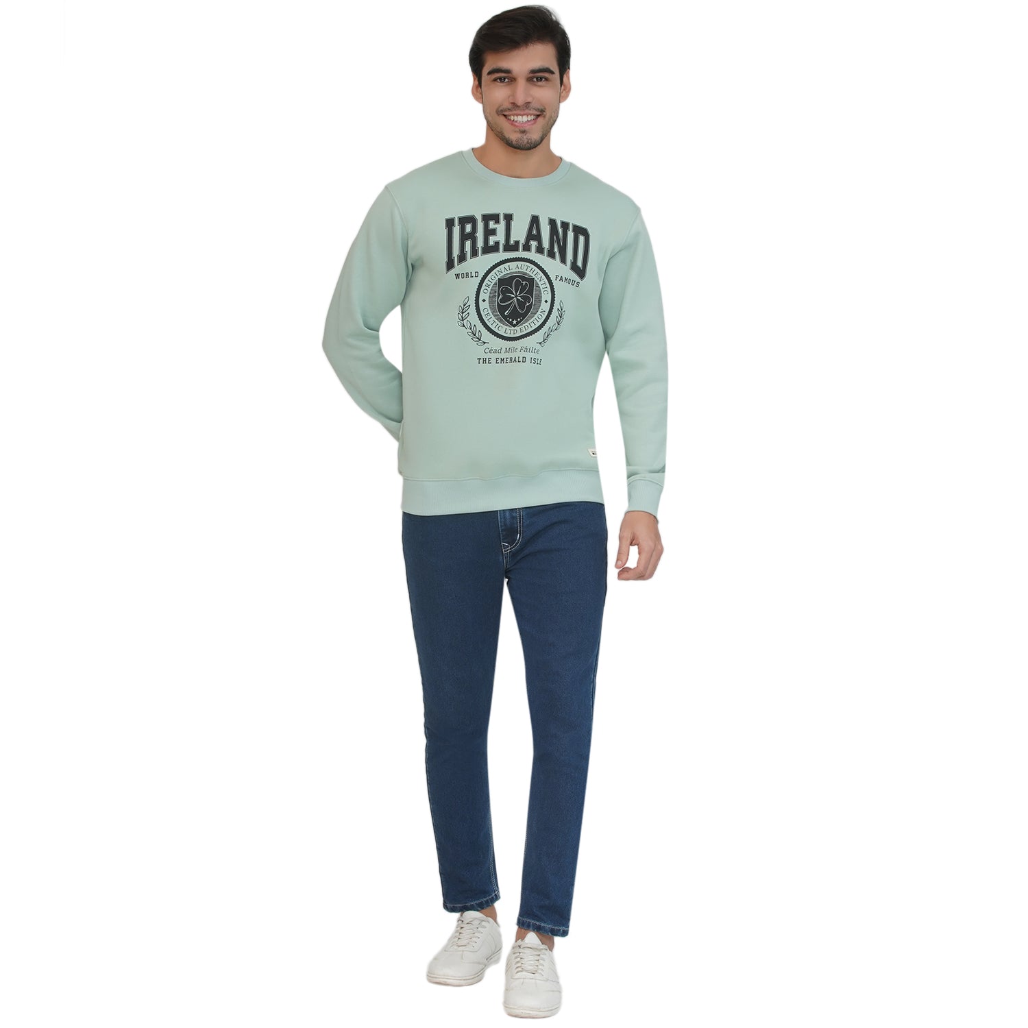 Male model wearing pistachio Ireland badge sweatshirt with crest graphic.