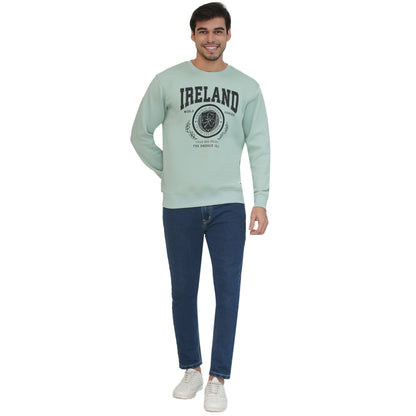 Male model wearing pistachio Ireland badge sweatshirt with crest graphic.