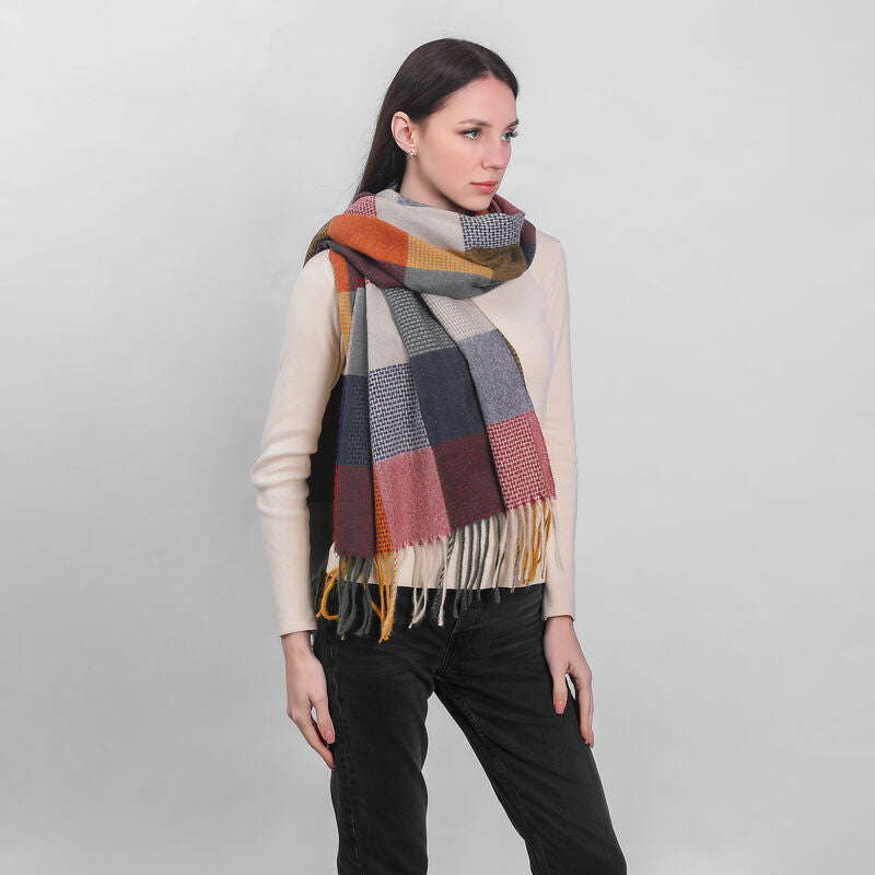 Woman wearing a large multicolored checkered scarf and light sweater