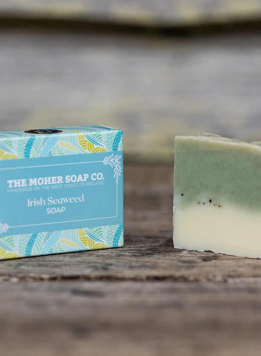 The Moher Soap Co Irish Seaweed Soap bar beside a blue box on a wooden surface.