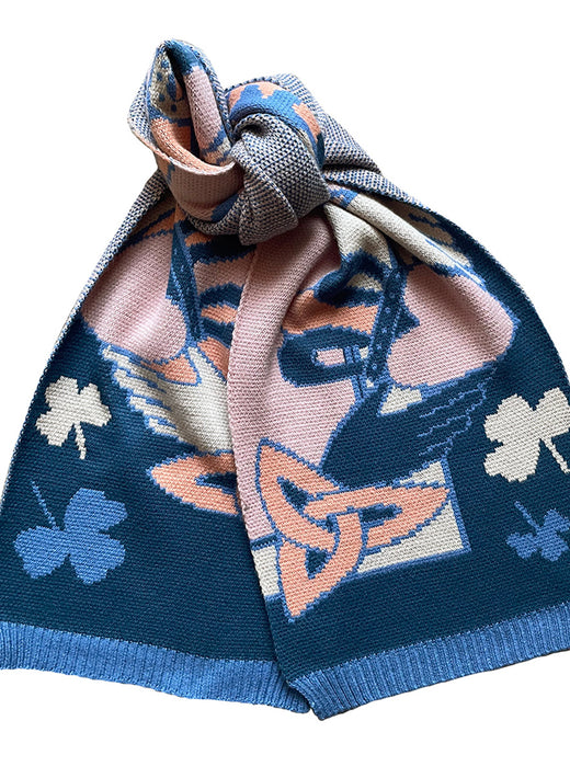 Blue and salmon knit scarf knotted, featuring bold floral and shamrock motifs.