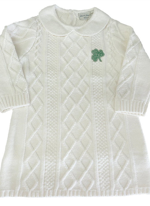 Cream Aran knit dress for girls with diamond and cable patterns and a green shamrock applique on the chest.