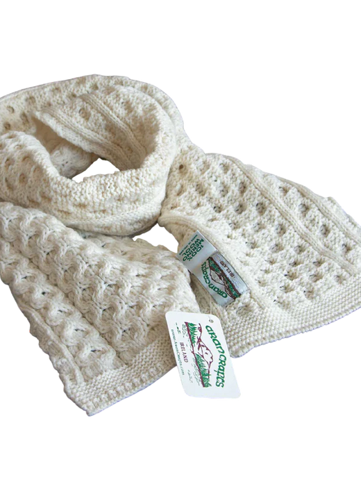 Cream-colored knitted scarf with textured patterns and tags attached