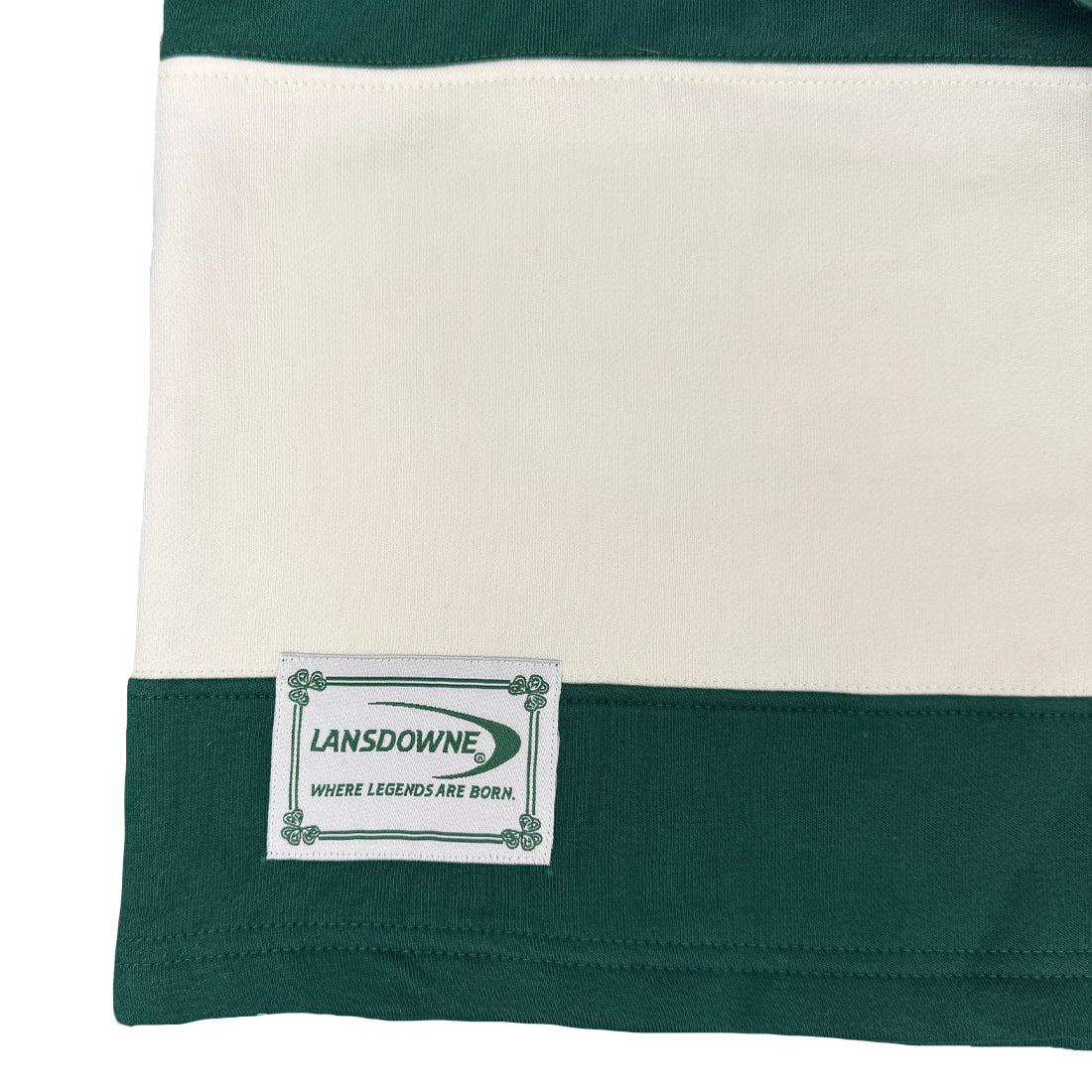 Close-up of the Lansdowne label on the striped rugby shirt hem.