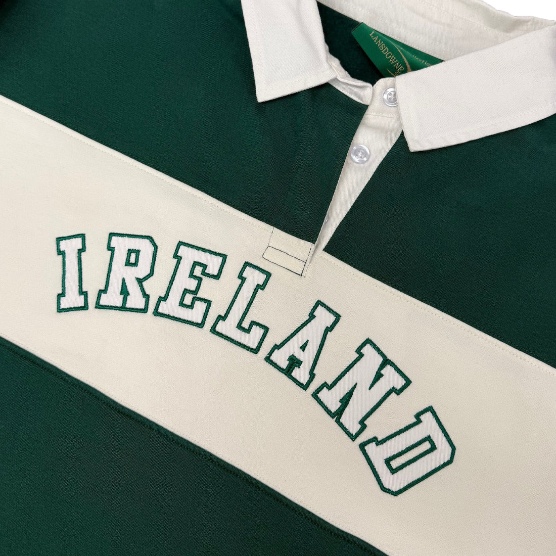 Close up of the green and cream striped Lansdowne Ireland rugby polo showing large IRELAND embroidery across the chest.