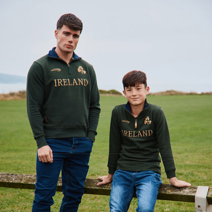 Two men wearing bottle green Ireland 1/4 zip fleeces pose in a grassy field.