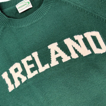 Close-up of green Ireland knitted jumper showing large white IRELAND lettering across the chest