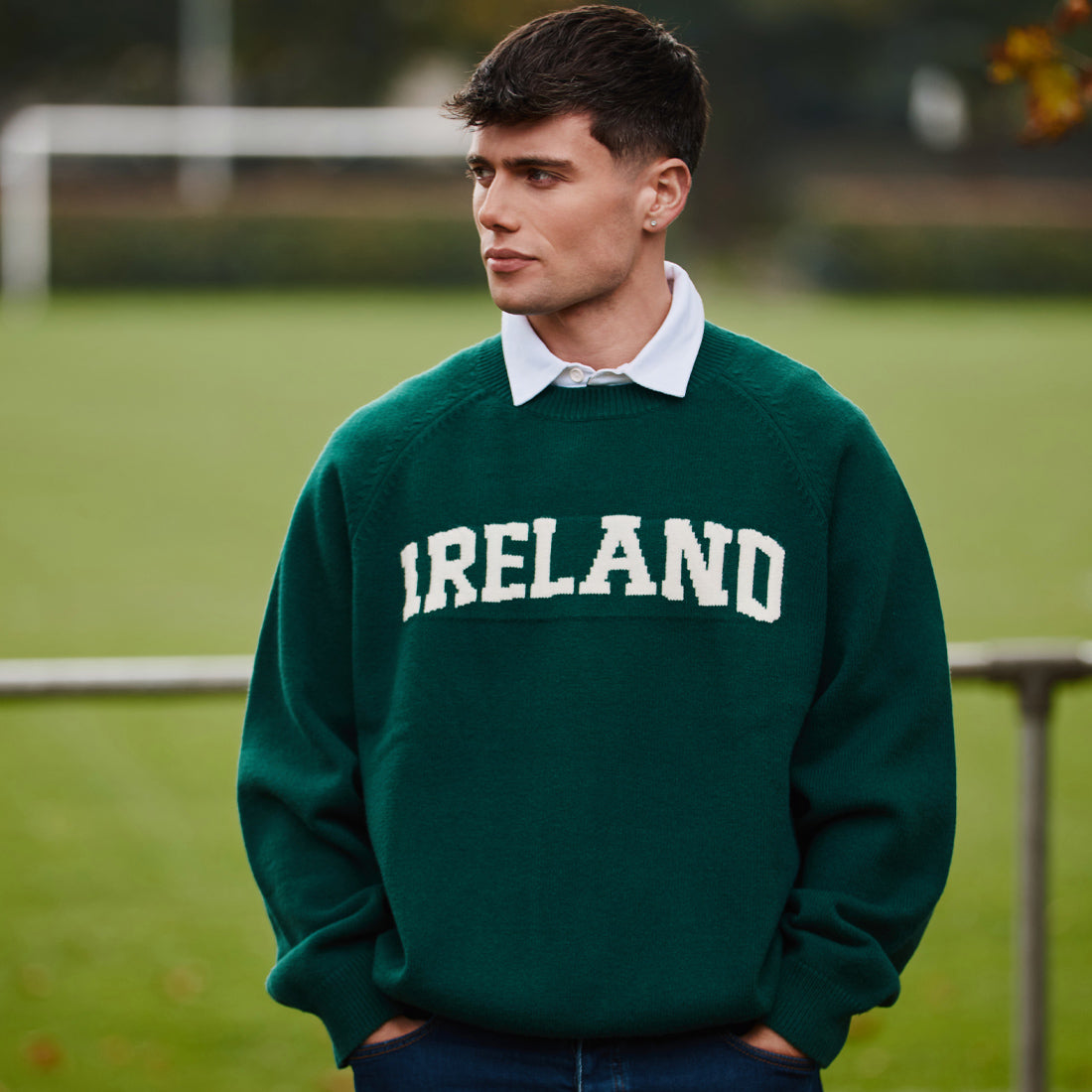 Male model wearing a green Ireland knitted jumper outdoors on a field