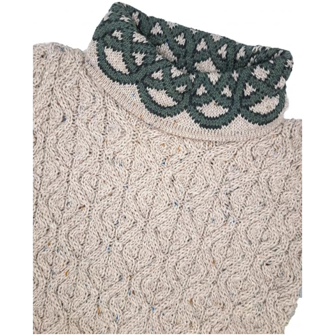 Close-up of beige knitted sweater with dark green patterned collar