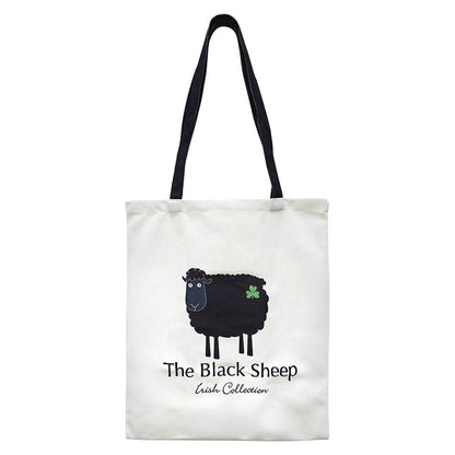 White tote bag featuring a black sheep graphic and a green shamrock with navy handles.