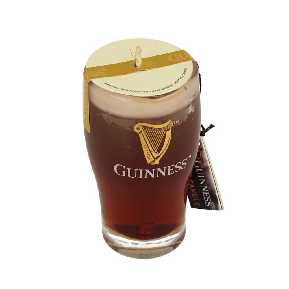 Glass shaped candle resembling a pint of Guinness beer with wick on top