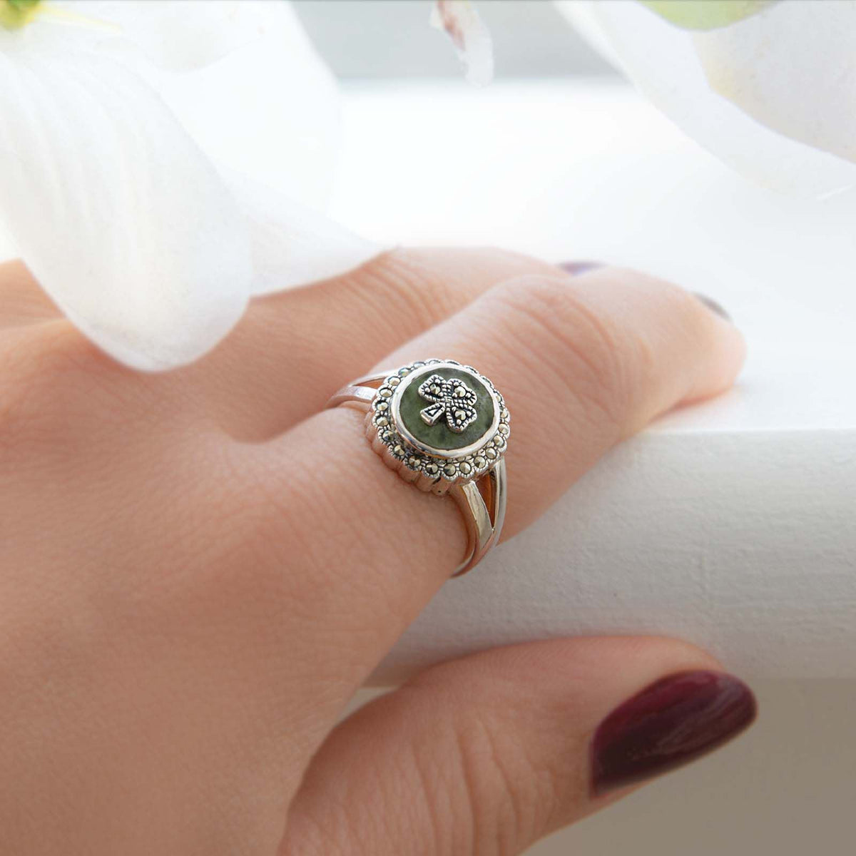 Side view of the silver marcasite shamrock ring featuring green Connemara marble on a fingertip.
