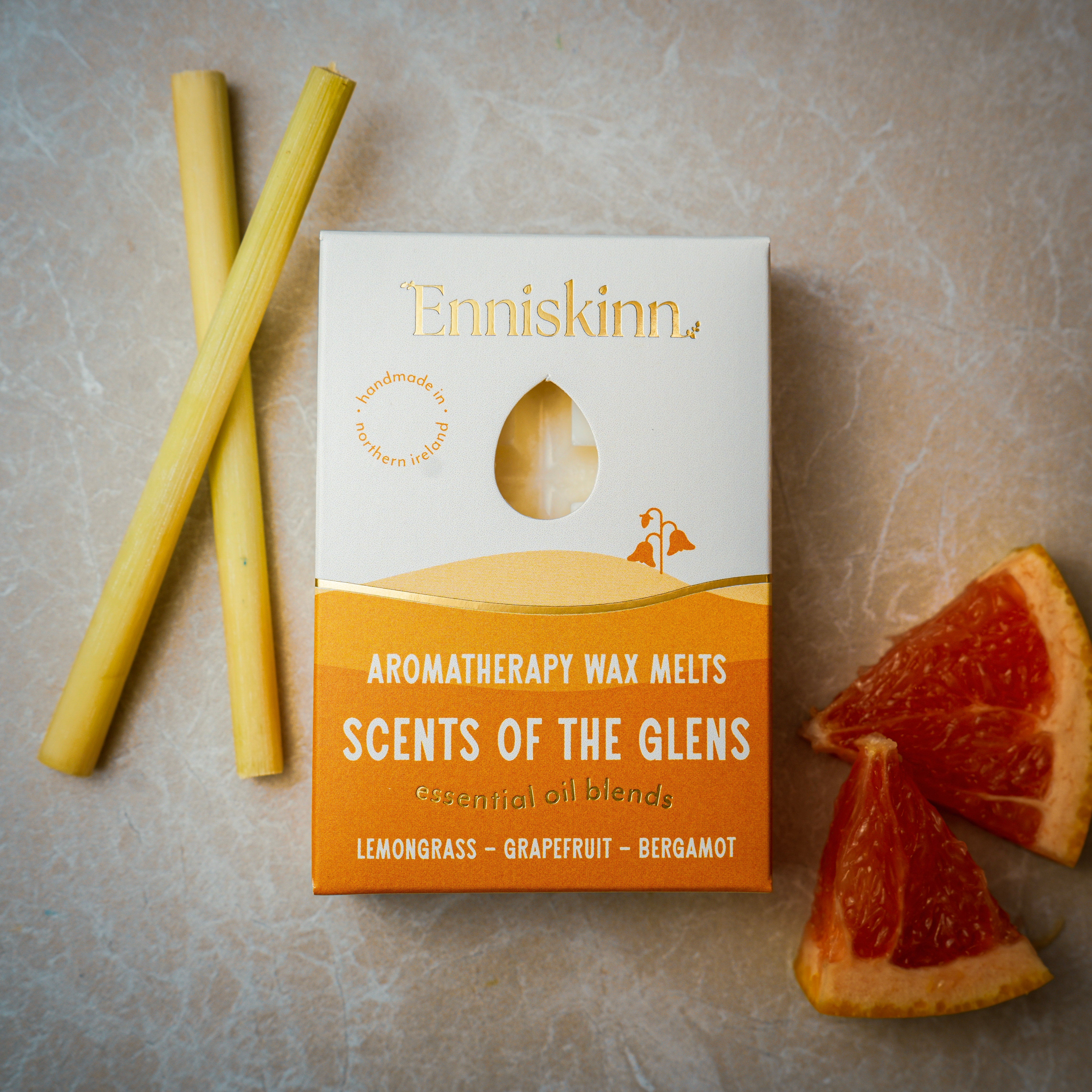 Enniskinn Scents of the Glens aromatherapy wax melts box with lemongrass grapefruit bergamot, shown with lemongrass stalks and grapefruit wedges.