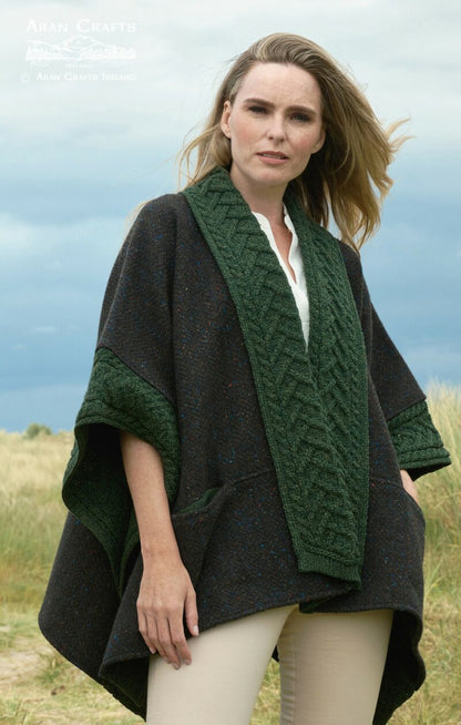 Woman wearing dark Donegal merino cape with green braided trim outdoors
