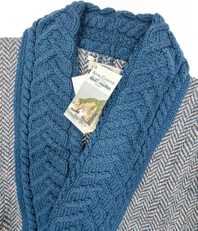 Close-up of blue knitted scarf with cable pattern on herringbone fabric