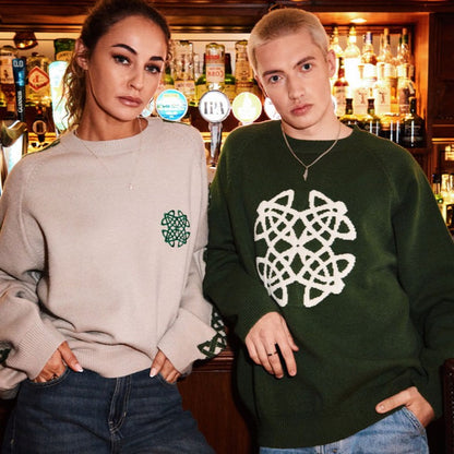 Two models wear Celtic Knot Stone crew neck sweaters in a bar; beige with green crest and a dark green version.