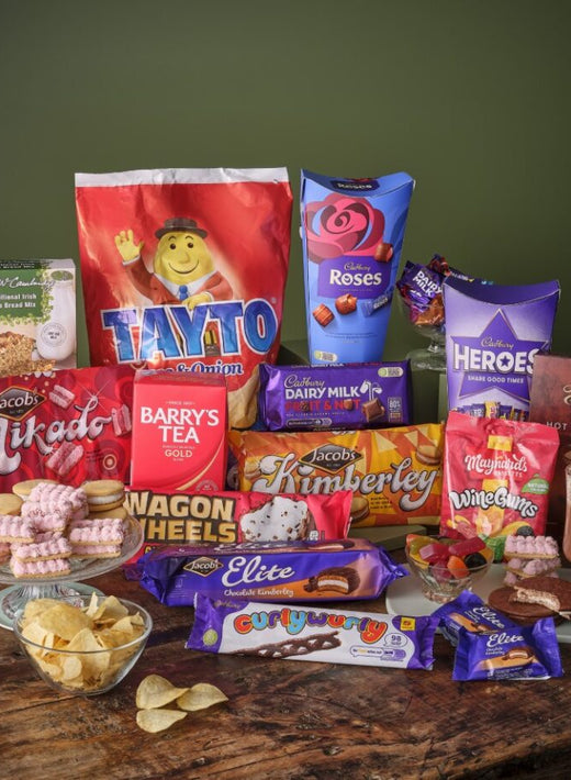 The Not Before Your Dinner Gift Basket filled with assorted snacks and treats on a wooden table