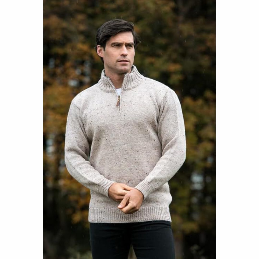 Man wearing beige knit sweater with half zipper standing outdoors