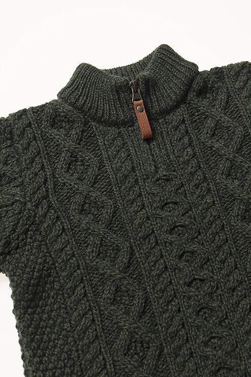 Close up of a dark green knit sweater with a high ribbed collar and a brown leather zipper pull