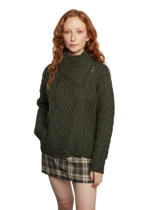 Woman with red hair wearing a dark green cable knit sweater and plaid skirt